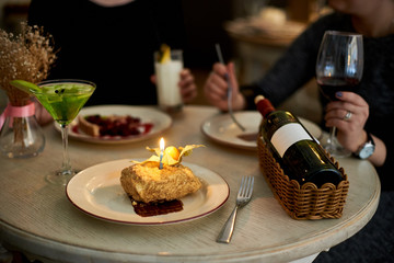 Girls party in cafe. Young woman drinking cocktails and wine and eating cakes. Female hands.