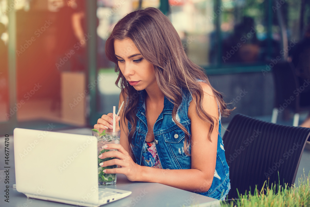 Wall mural gorgeous cheerful woman freelancer in a good mood, using laptop computer, sitting in cafes, sipping 