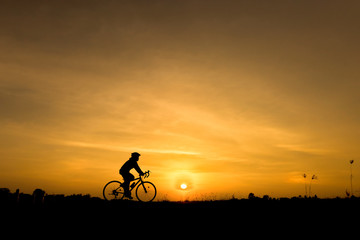 Fototapeta na wymiar Silhouette of cycling on sunset background