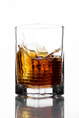 A glass of whiskey in which poured on a white background.