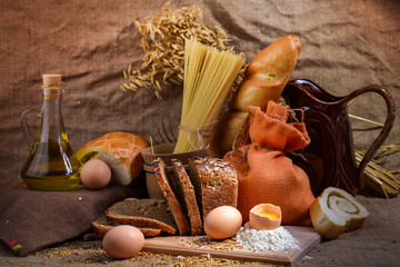 still life of bread and millet in old style on a linen cloth with a distinct texture. The figure also oil and grain cereals and eggs.