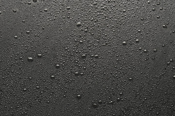 Drops of water on a black surface. The condensate. Top view. Free space.