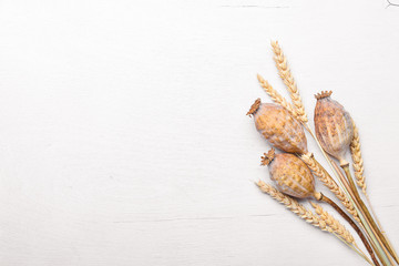The heads of poppy and wheat. On Wooden background. Top view. Free space.