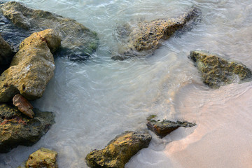 Rocks on soft sandy beach