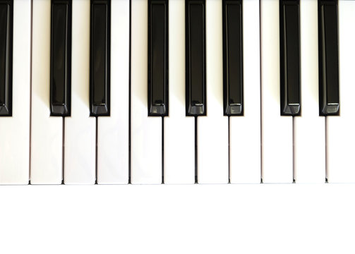 Piano keyboard with white and black keys on white background top view vertical  photo close up
