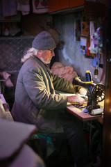Senior adult man with sewing machine