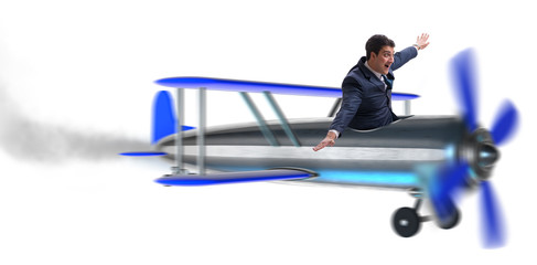 Businessman flying on vintage old airplane on white
