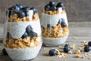 blueberry yogurt parfait with granola, oats and chia seeds in glasses - obrazy, fototapety, plakaty