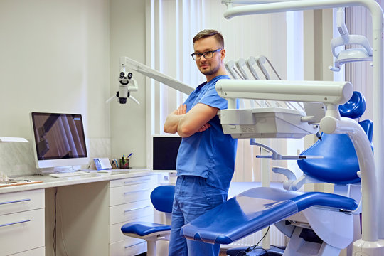 Male dentist in a room with medical equipment on background.