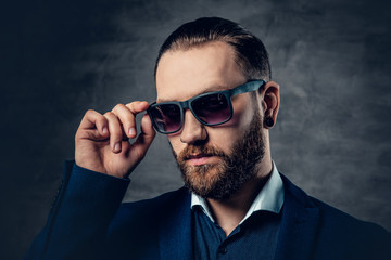 Obraz premium Studio portrait of bearded male in sunglasses and piercing in a nose.