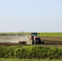 Fototapeta premium A tractor with a plow lays the soil. Soil cultivation on the fie