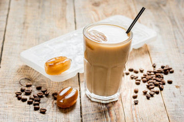 Ice coffee with milk and beans for lunch on wooden background
