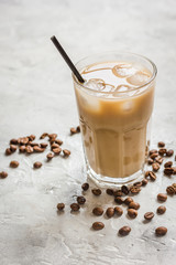 cold coffee glass with ice cubes on stone table background