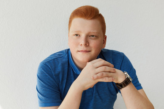 An elegant young handsome man with red hair and freckles wearing blue shirt and watch holding his hands together isolated over white background dreaming about something looking into distance Stock Photo | An elegant young handsome man with red hair and freckles wearing blue shirt and watch holding his hands together isolated over white background dreaming about something looking into distance Stock Photo |