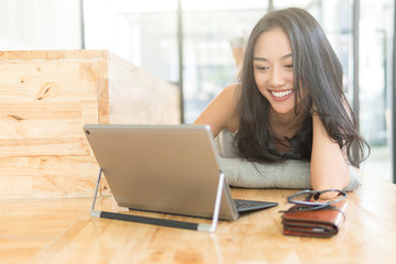 Fototapeta premium woman relaxing lifestyle with laptop computer,playing with laptop on the floor,day light flare color effect and selective focus