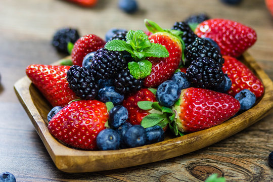 Mix Berries strawberries, blueberries, blackberries on Wooden Background. Summer Organic Berry over Wood. Agriculture, Gardening