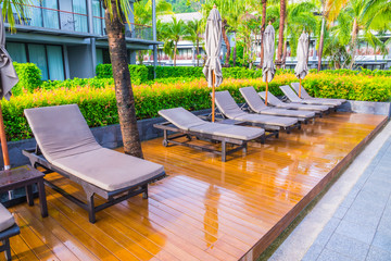 Swimming pool with relaxing seats near the sea .