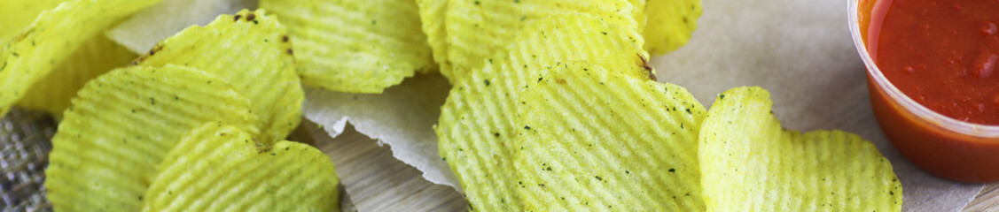 Horizontal bakground of potato chips on a table