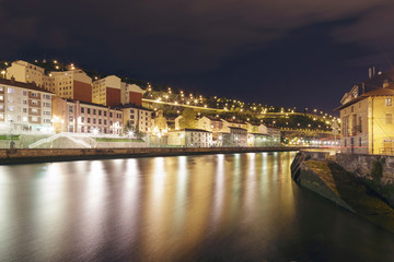 View at night of the city of Bilbao, Basque Country, Spain. Olabeaga and Zorrozaurre districts separated by the Nervion river. Long exposure shot.