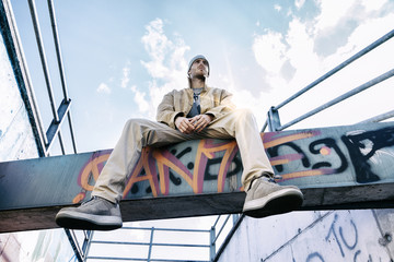 a rap singer on a concrete beam in a subway - obrazy, fototapety, plakaty