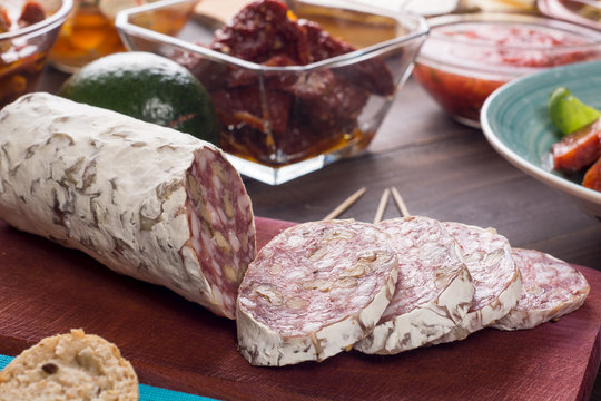 Salami with walnuts on wooden boards