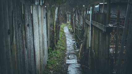 A pedestrian road passing between old fences