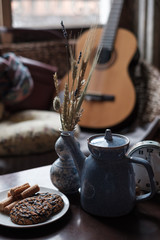 Preparation for morning tea. A cup and a teapot on the table are among the cute interior details.