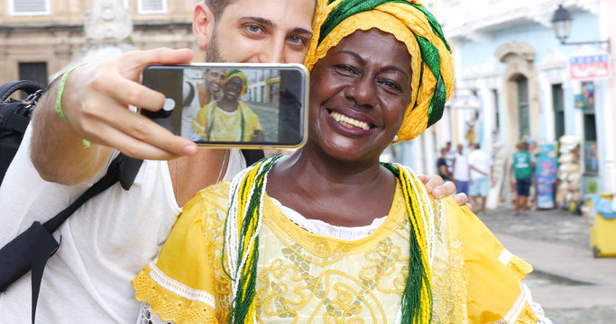 Tourist taking a selfie with a Baiana in the old colonial district of Salvador, Brazil