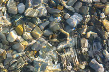 Obraz premium sea pebble beach with multicoloured stones, waves with foam
