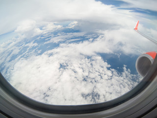Clouds and sky as seen through window of an aircraft.