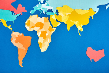 World map cut out of colored paper based on blue.