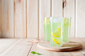 homemade lemonade with fresh lemon and mint on a wooden background