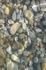 sea pebble beach with multicoloured stones, waves with foam
