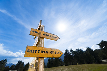 Signs at the golf course against blue sky