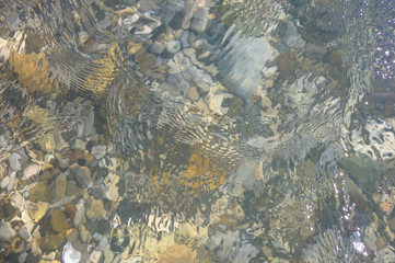 sea pebble beach with multicoloured stones, waves with foam