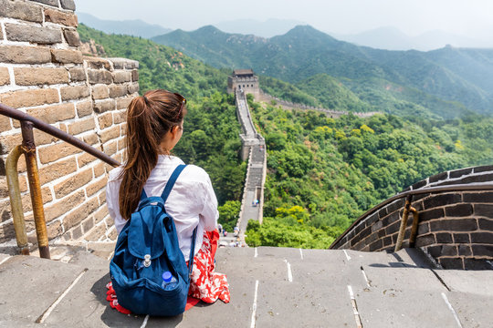 Great Wall of china. Tourist on Asia travel looking at Chinese landscape sitting relaxing on famous Chinese tourist destination and attraction in Badaling north of Beijing. Woman traveler on vacation.