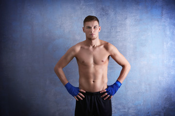 Young sporty man on color background