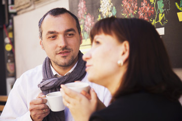 Young couplein love enjoying coffee  in old European town (Flirting, relationships, summer, tourism, drinks concept)