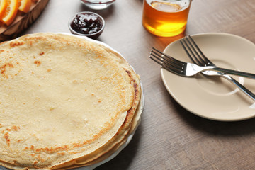 Plate with delicious pancakes on table