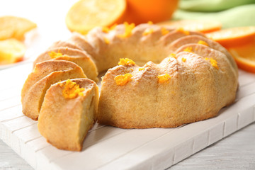 Sliced citrus cake on white wooden board