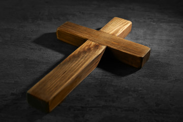 Wooden cross on gray background