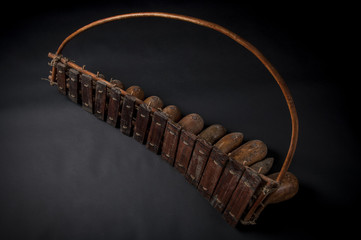 African music instrument, wooden marimba with two bakets, isolated on dark background