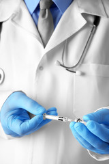 Doctor with syringe and medicine, closeup