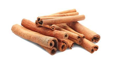 Heap of cinnamon sticks on white background