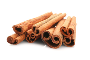 Heap of cinnamon sticks on white background