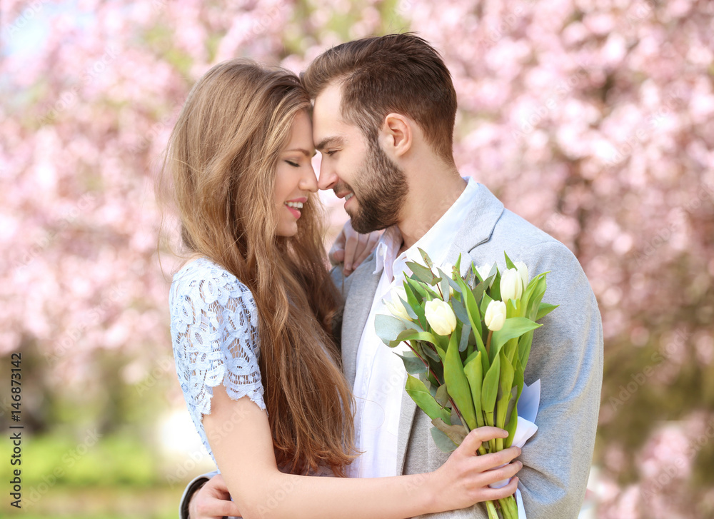 Poster Young lovely couple walking in spring park