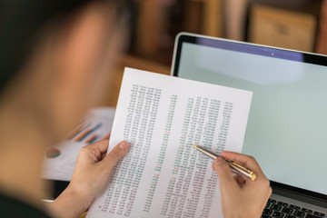 Business woman hand with Financial charts and laptop on the table .