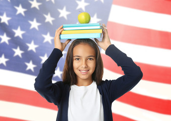 Cute schoolgirl with books and apple on white background