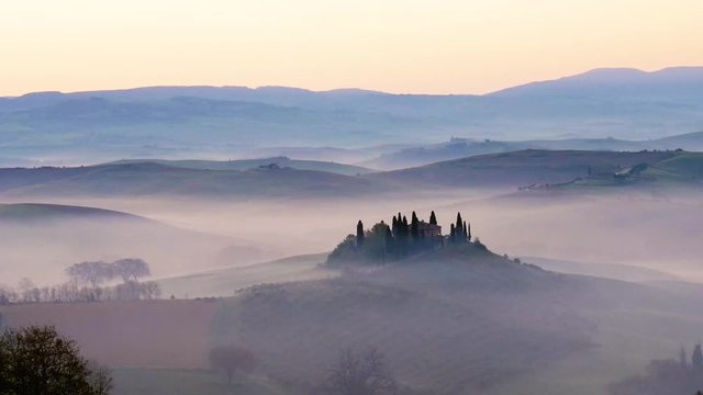 Panoramic video of a landscape of the Tuscan hills during sunrise with fog in the Val d'Orcia