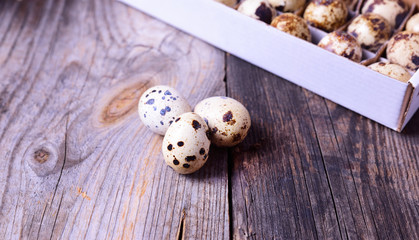Obraz premium Three fresh quail eggs on a gray wooden surface
